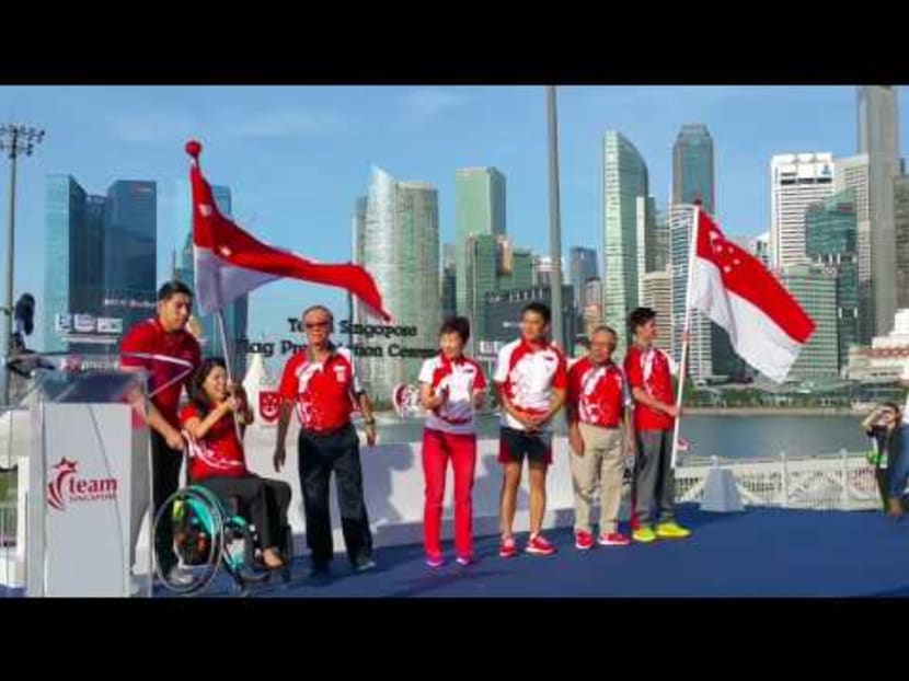 Swimmer Yip Pin Xiu receives the Singapore flag she will be bearing at the Rio Paralympics