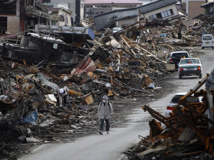 In this March 23, 2011 file photo, a resident walks between the rubble caused by the March 11 tsunami at Kesennuma, Miyagi Prefecture, northern Japan. Photo: AP