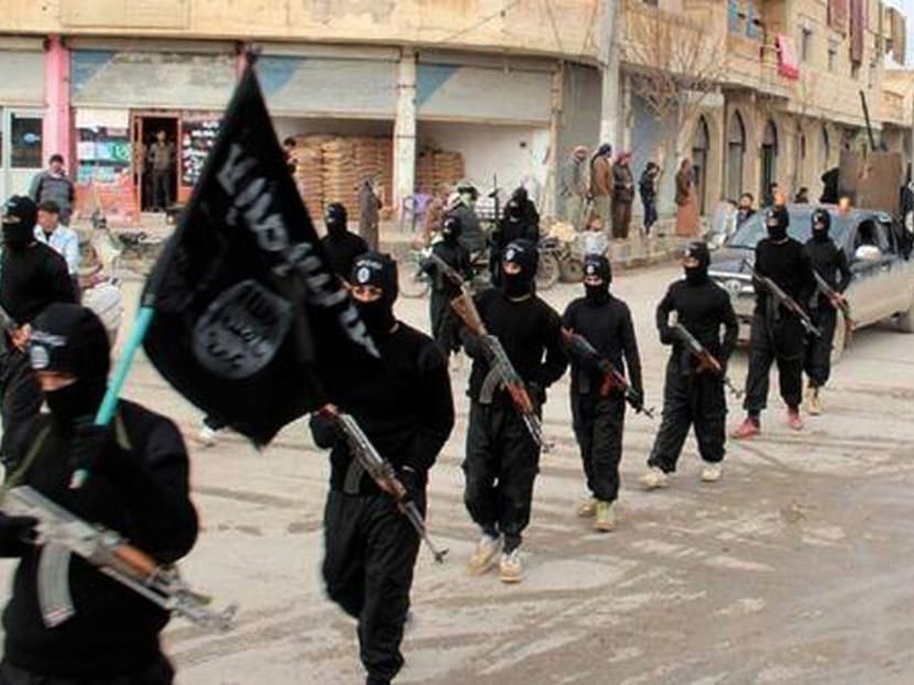 Islamic State fighters marching in Raqqa, Syria. Photo: AP