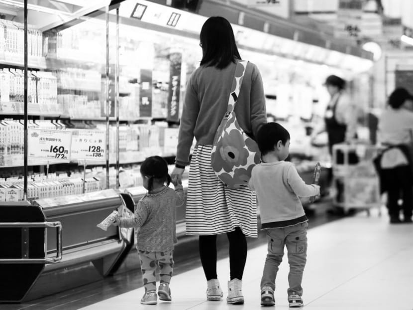 A mother and her children in an Aeon supermarket in Chiba. The consumption tax rate in Japan has been increased and measures to address deflation are pushing up prices. Photo: Bloomberg