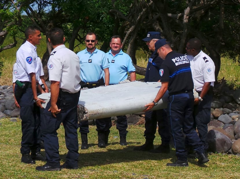 French gendarmes and police carry a large piece of plane debris which was found on the beach in Saint-Andre, on the French Indian Ocean island of La Reunion, July 29, 2015. Photo: Reuters