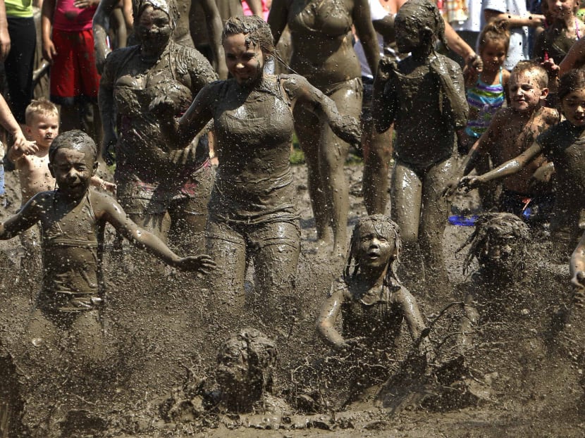 Children run into the mud in during the annual Mud Day event. Photo: AP