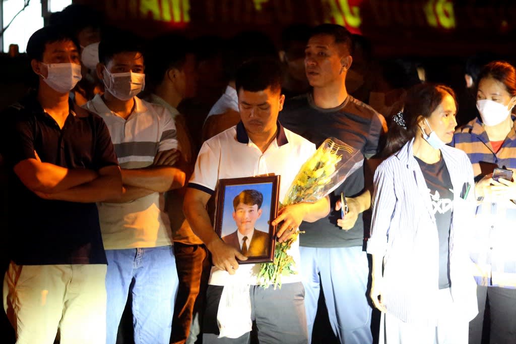 This picture taken on Sept 7, 2022 shows a family member holding a portrait of a victim of the An Phu karaoke bar fire waiting outside the morgue at Thuan An General Hospital in Thuan An in Vietnam's Binh Duong province, north of Ho Chi Minh City. This picture taken on Sept 7, 2022 shows a family member holding a portrait of a victim of the An Phu karaoke bar fire waiting outside the morgue at Thuan An General Hospital in Thuan An in Vietnam's Binh Duong province, north of Ho Chi Minh City.