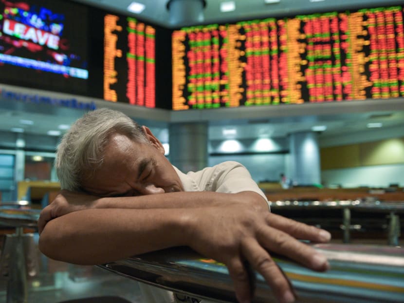 A trader at the Malaysia Stock Exchange in Kuala Lumpur taking a nap. The AIA Vitality Healthiest Workplace survey shows that about half of employees in Hong Kong, Singapore, and Malaysia have reported problems with sleep. Photo: AFP