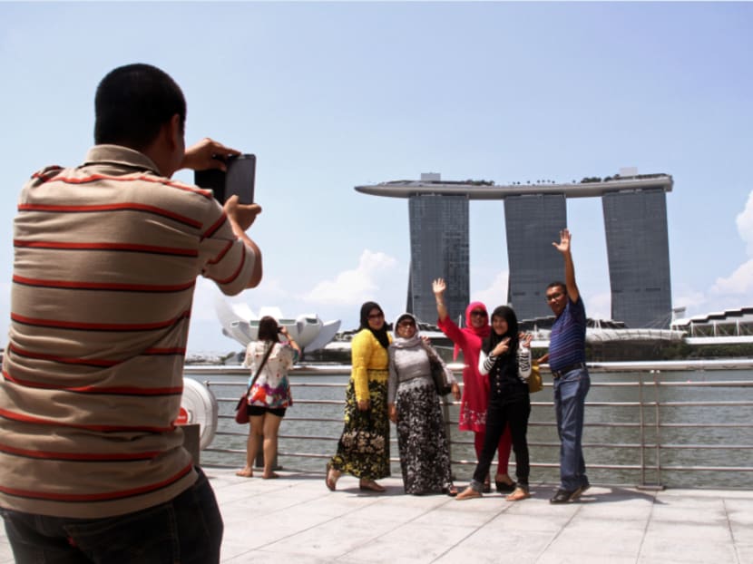 Tourists pose for a photo with Marina Bay Sands in the background. TODAY file photo