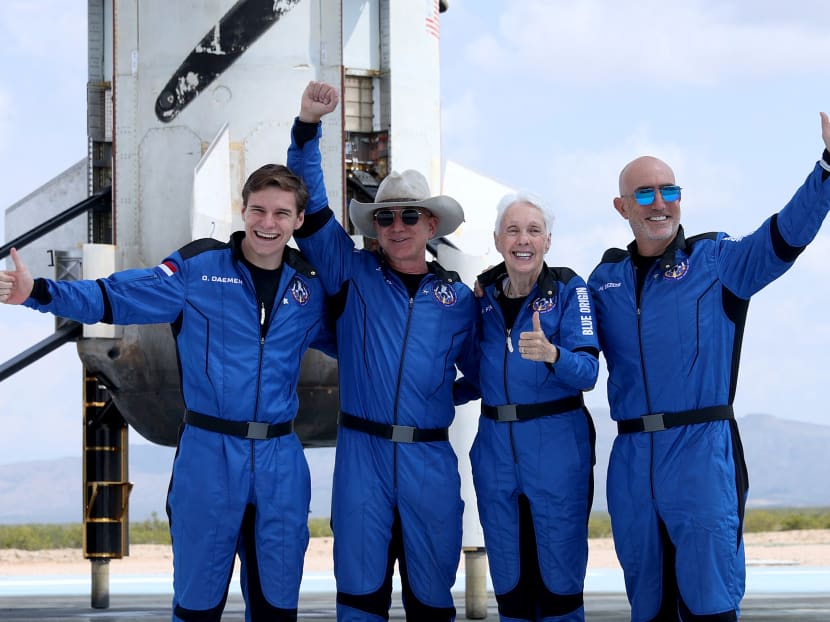 Blue Origin’s New Shepard crew Oliver Daemen, Jeff Bezos, Wally Funk, and Mark Bezos (left to right) pose for a picture near the booster after flying into space in the Blue Origin New Shepard rocket in Van Horn, Texas, US on July 20, 2021.