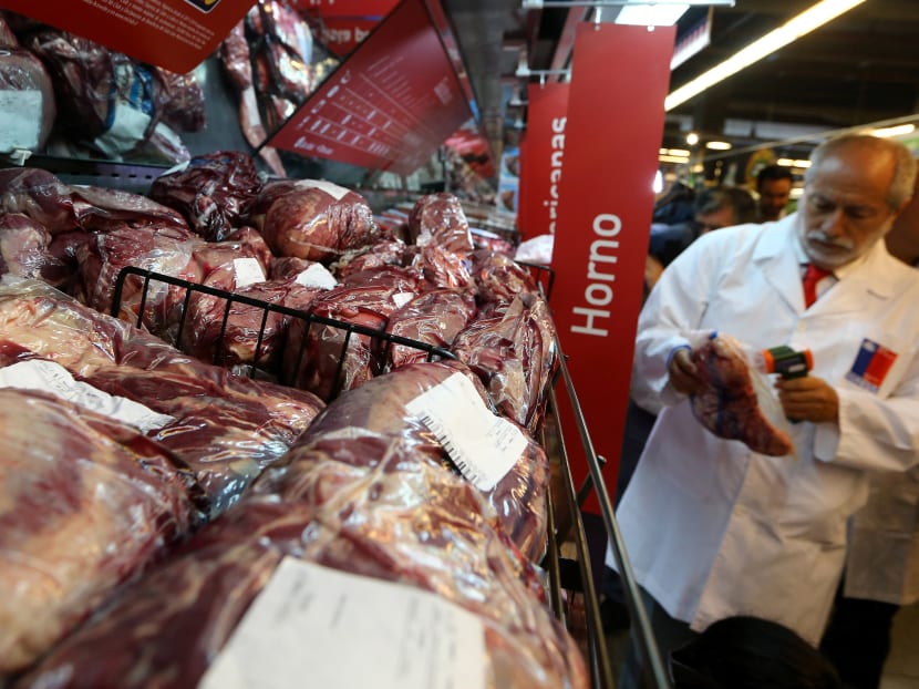 A member of the Public Health Surveillance Agency measures the temperature where the products are exposed at a supermarket after the Chilean government suspended all meat and poultry imports from Brazil, in Santiago, Chile. Photo: Reuters