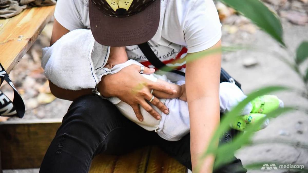 a-mother-hold-a-baby-in-a-park.jpg?itok=