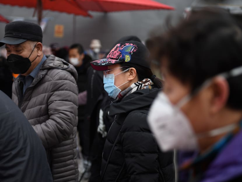 Local residents wear masks as a preventive measure against the Covid-19 coronavirus as they shop for fruit and vegetables in a busy market in Beijing on Feb 27, 2020.