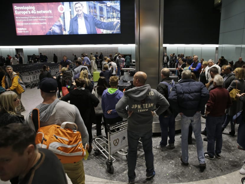 People wait, in the luggage hall of Terminal 5 at Heathrow Airport in London, Dec 12, 2014. Photo: AP