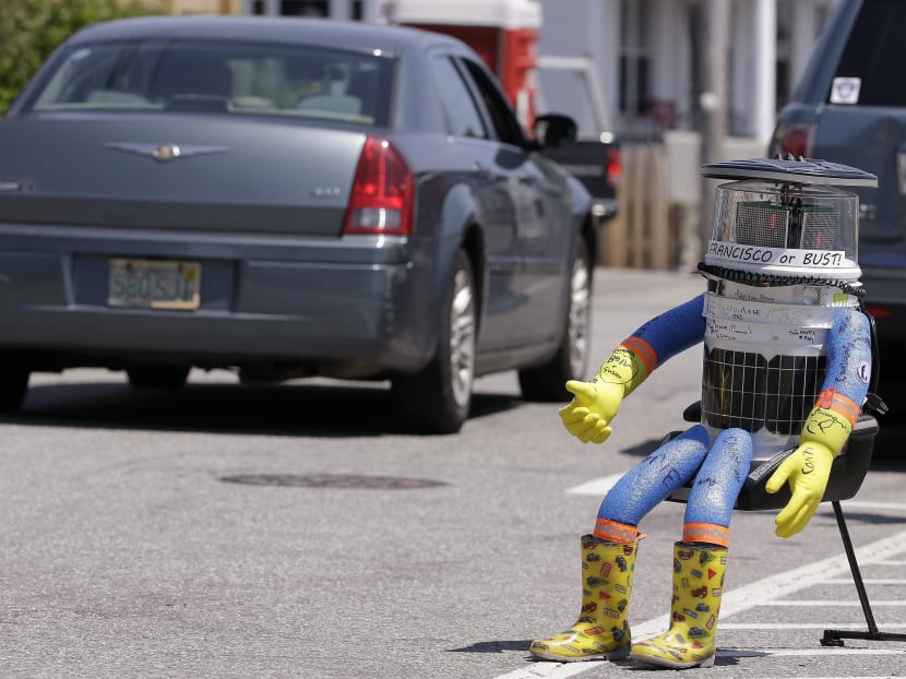 A car drives by HitchBOT, a hitchhiking robot in Marblehead, Massachusetts. The Canadian researchers who created hitchBOT as a social experiment say someone in Philadelphia damaged the robot beyond repair on Saturday, Aug 1. Photo: AP