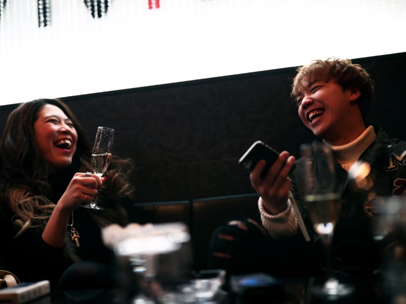 In this picture taken on Jan 23, 2017, 27-year-old businesswoman Aki Nitta (L) drinks champagne as she shares a light moment with her host Shia (R) at a host club in the Kabukicho red-light district in Tokyo. Photo: AFP
