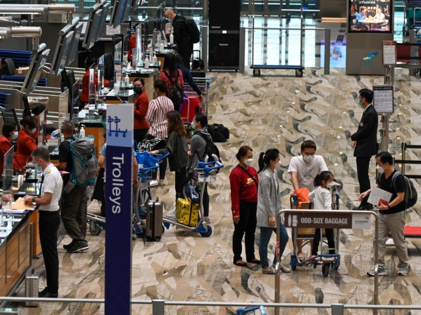 Travellers checking in for their flight at a Singapore Airlines counter in the departure hall area of Changi International Airport.
