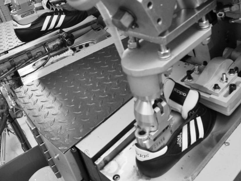 A machine attaching the plastic sole to a football shoe at an Adidas factory in Germany. This month, Adidas’ CEO announced that the company would bring some shoe production back to Germany for the first time in three decades thanks to a highly-automated factory in Bavaria. Photo: Bloomberg