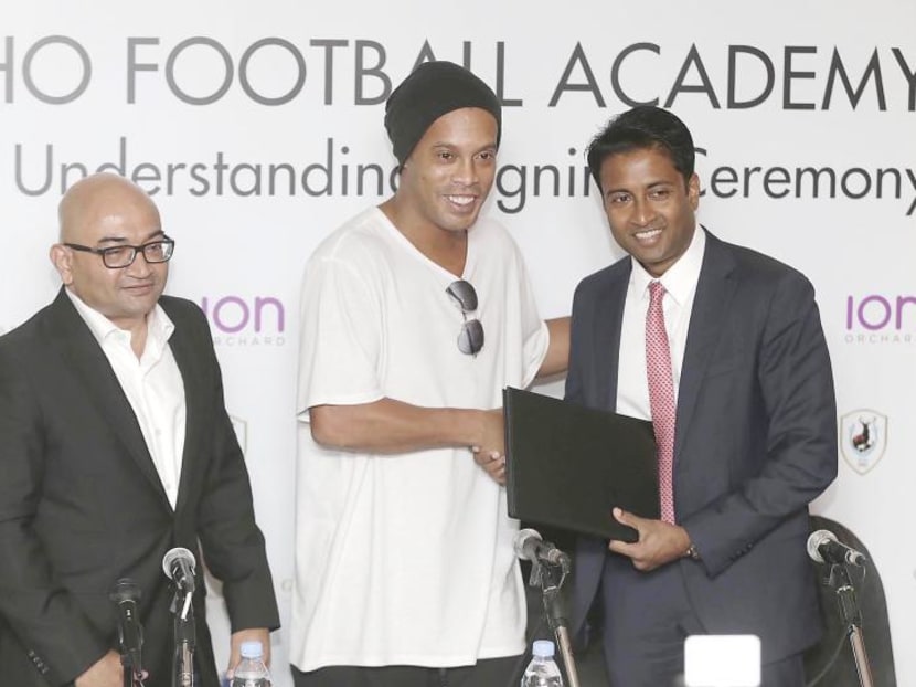 Tampines Rovers chairman Krishna Ramachandra (right) started a partnership with Brazilian football star Ronaldinho (centre) in December 2015 to set up an academy here. However, the academy had closed down without conducting a single training session. TODAY File Photo