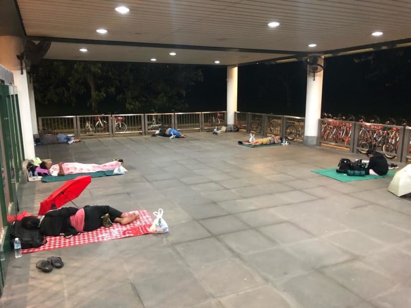 Malaysian workers seen sleeping behind the gates of Kranji MRT Station on March 18, 2020. Social and Family Development Minister Desmond Lee said many of the nearly 300 people who had sought shelter were affected by travel restrictions.