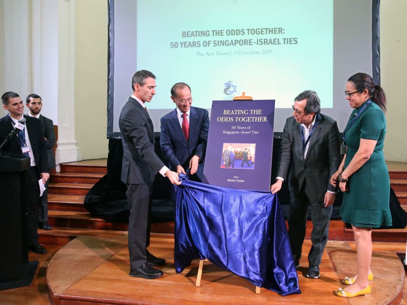 Unveiling the cover of the book, Beating the Odds Together: 50 Years of Singapore-Israel Ties, are (from left) Mr Sagi Karni, ambassador of Israel to Singapore; Mr George Yeo, Singapore's former foreign affairs minister;
Mr Bilahari Kausikan, former permanent secretary of foreign affairs; and Ms Michelle Teo, acting director of the Middle East Institute.