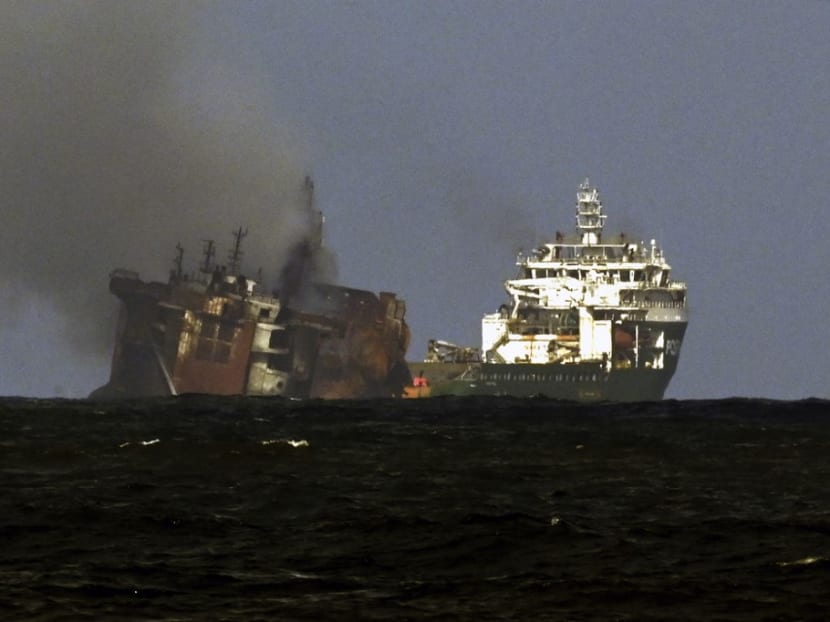 A tugboat (Right) from the Dutch salvage firm SMIT tows the fire stricken Singapore-registered container ship MV X-Press Pearl away from the coast of Colombo on June 2, 2021 following Sri Lankan President Gotabaya Rajapaksa's order to move the ship to deeper water to prevent a bigger enviromental disaster.