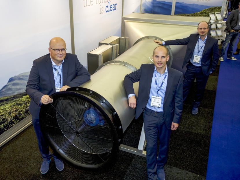 A handout photo released by tech start-up Envinity Group shows (from L) the group's Managing Partners Peter van Wees, Simon van der Burg and Tim Petter posing next to a system created by van Wees to filter fine and ultra-fine particles from ambient air at the Offshore Energy 2016 Exhibition & Conference in Amsterdam on October 25, 2016. Photo via AFP