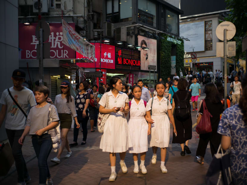 School students walk down a street in Hong Kong on July 4, 2016. Source: AFP