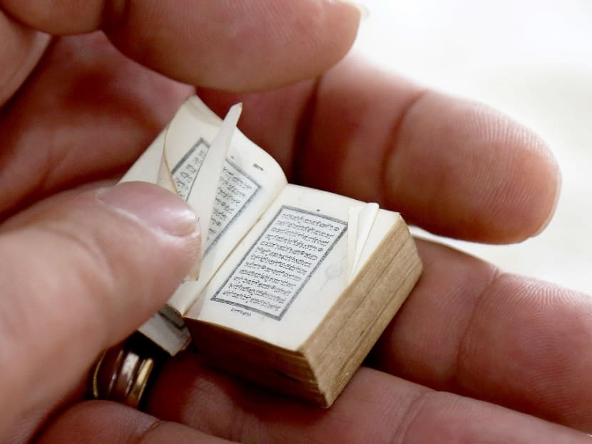 Mario Prushi holds in his hand one of the smallest Qurans (Islam's holy book), of a postage-stamp size with a cover crafted from gold embroidered velvet, in Tirana, Albania, on April 17, 2023. 