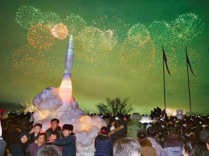 Fireworks are seen above the Taedong River during New Year celebrations as visitors pose for a photo in front of an ice sculpture of an intercontinental ballistic missile at the Pyongyang Ice Sculpture Festival in North Korea.  The author says war with North Korea is moving from the unthinkable into the thinkable column. Photo: Kyodo News