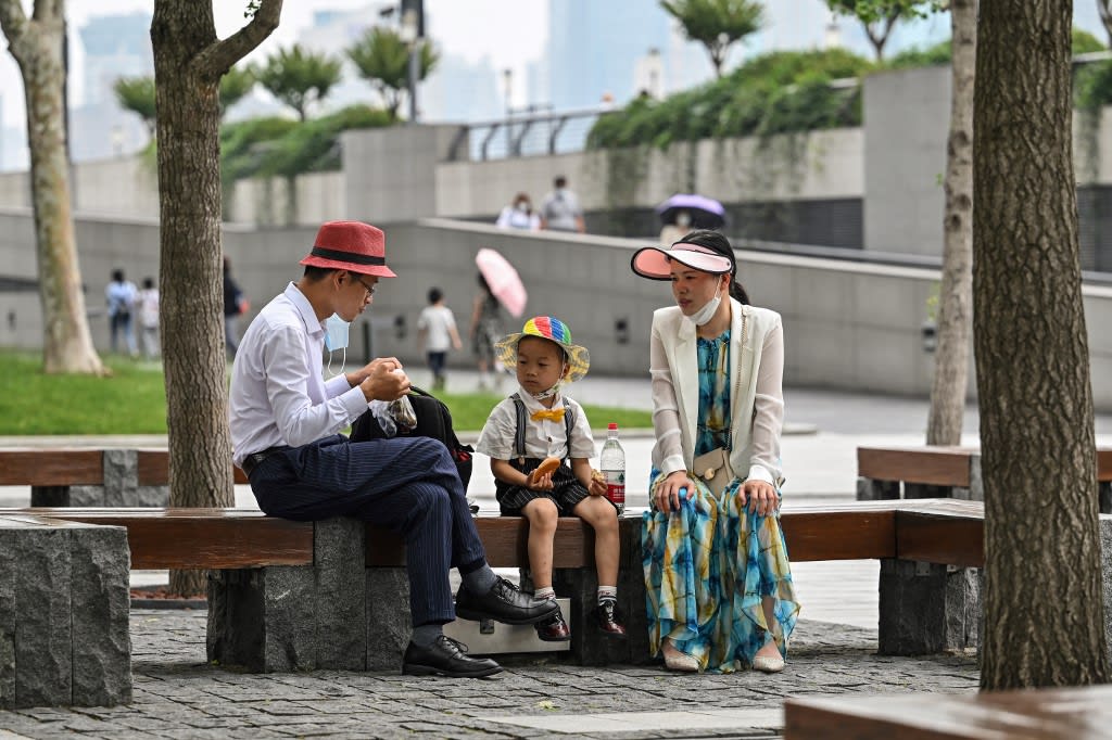 A family sits in a park on The Bund in the Huangpu district of Shanghai on June 1, 2022, following the easing of Covid-19 restrictions in the city after a two-month lockdown.