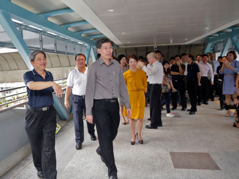Minister for Transport Lui Tuck Yew (in grey) visiting one of the two new sheltered pedestrian link bridges at Clementi MRT Station today (Aug 25). Photo: Wee Teck Hian