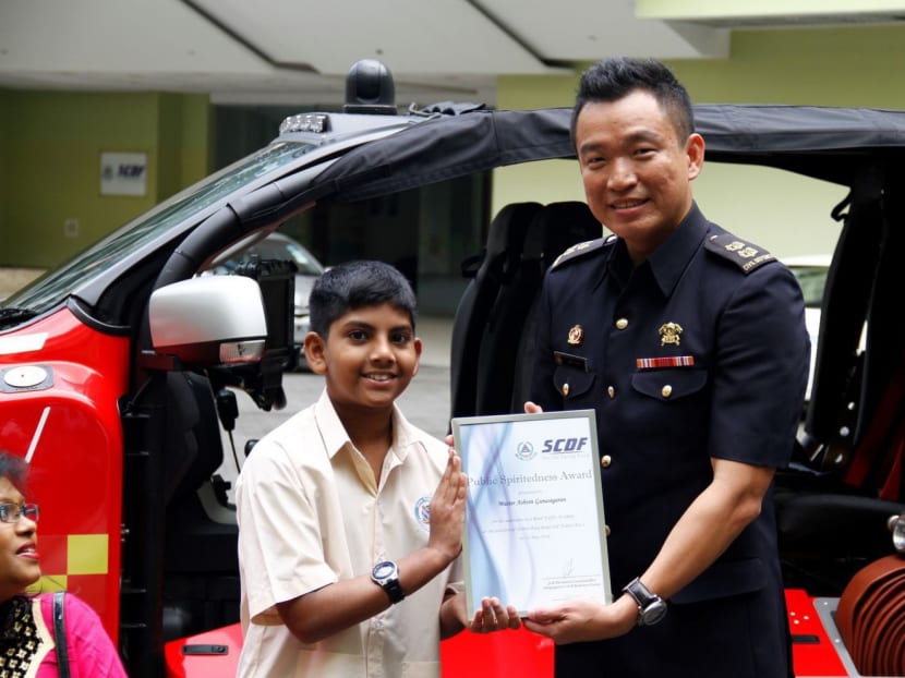 Ashvin Gunasegaran, 12, being presented with the Public Spiritedness Award by the SCDF on June 2. While bystanders at the scene of a car accident merely whipped out their phones to take photos, Ashvin stepped forward to help. Photo: Illiyin Anuwar