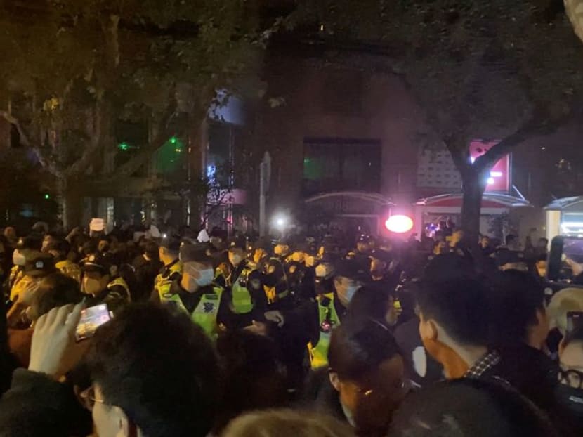 Police officers drive people away during a protest against coronavirus disease (Covid-19) curbs in Shanghai, China, Nov 27, 2022, in this screen grab obtained from a social media video. Police officers drive people away during a protest against coronavirus disease (Covid-19) curbs in Shanghai, China, Nov 27, 2022, in this screen grab obtained from a social media video.