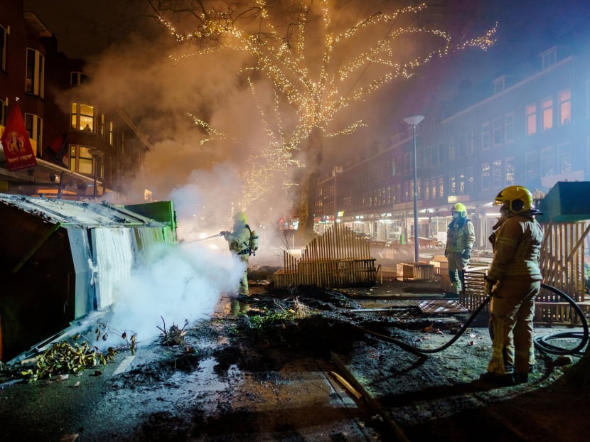 Firefighters work to extinguish a fire on the Groene Hilledijk in Rotterdam on Jan 25, 2021, after a second wave of riots in the Netherlands following the introduction of a Covid-19 curfew over the weekend.