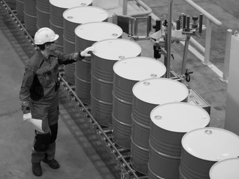 An employee checks sealed oil barrels as they move along a conveyor belt after filling at Royal Dutch Shell's lubricants blending plant in Torzhok, Russia. Falling oil prices should have a positive effect on the global economy. Photo: Bloomberg