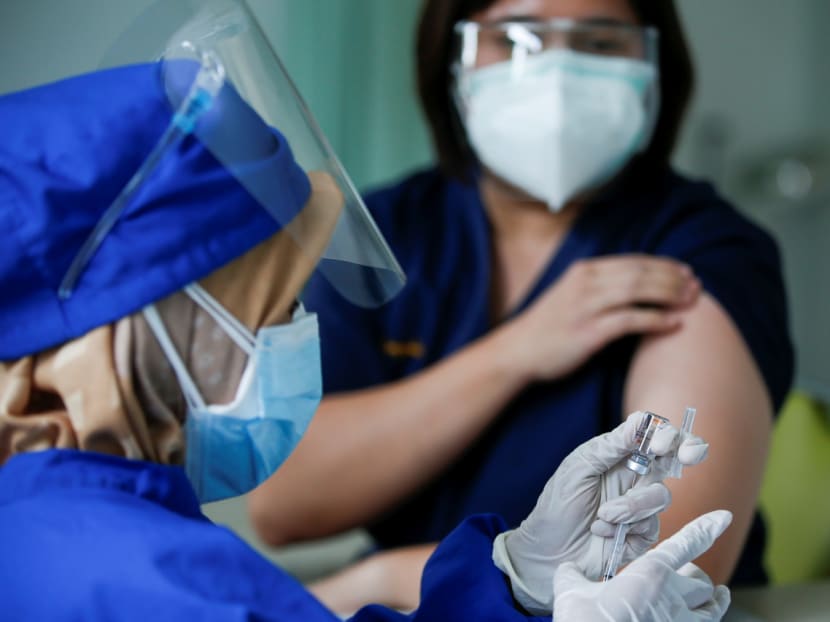 A medical worker prepares a dose of the Sinovac vaccine for Covid-19 before giving it to a doctor at a district health facility in Jakarta, Indonesia on Jan 19, 2021.