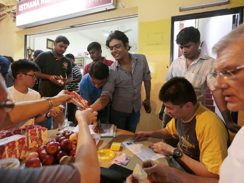TWC2 staff and volunteers handing out meal coupons, apples and drinks to migrant workers. Photo: Jason Quah/TODAY TWC2 staff and volunteers handing out meal coupons, apples and drinks to migrant workers. Photo: Jason Quah/TODAY