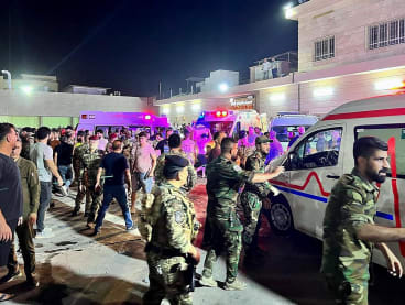 Soldiers and emergency responders gather around ambulances carrying wounded people after a fire broke out during a wedding at an event hall, outside the Hamdaniyah general hospital in Al-Hamdaniyah, Iraq on Sept 27, 2023.