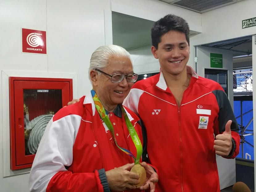 Newly-crowned Olympic 100m butterfly champion and record-breaker Joseph Schooling (right) sportingly lets Singapore President Dr Tony Tan Keng Yam wear his historic Olympic gold medal in Rio. Photo: Low Lin Fhoong/TODAY
