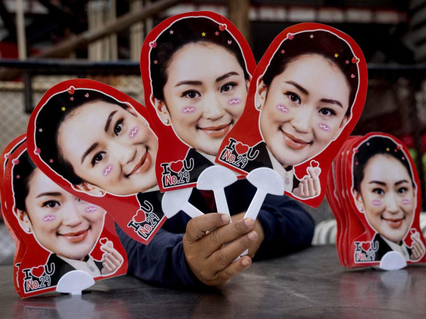 A woman holds up placards featuring Thai candidate for prime minister Paetongtarn Shinawatra during an election rally for Thailand's main opposition Pheu Thai party in Bangkok on April 5, 2023.