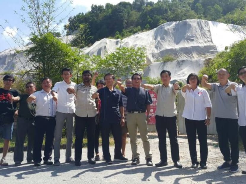 The Taman Lau Geok Swee residents and Penang Gerakan leaders at the proposed development project in Paya Terubong with the hillslope behind them. Photo: Malay Mail Online
