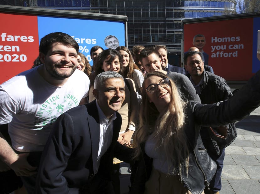Sadiq Khan, Britain's Labour Party candidate for Mayor of London, poses for a selfie with supporters at Canary Wharf in London, Britain May 4, 2016. Photo: Reuters