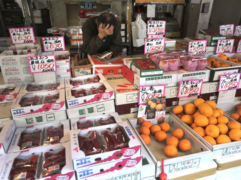 In this March 28, 2014 file photo, a fruits shop clerk waits for customers at Tsukiji fish market in Tokyo. Photo: AP