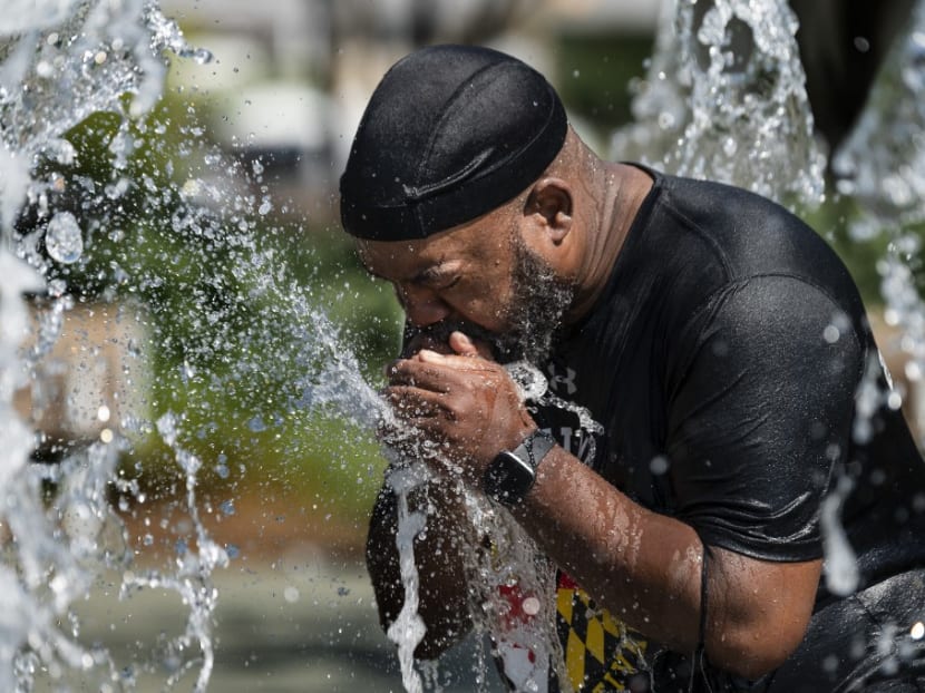 A man cools off in a fountain at Inner Harbor in Baltimore, Maryland, on June 30, 2021, as a heat wave threatens to make it Baltimore’s hottest day of the year.