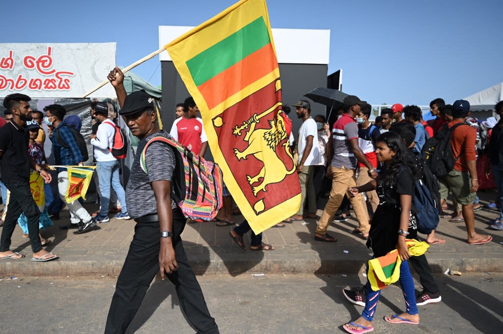 A man waves Sri Lanka's national flag outside presidential secretariat in Colombo on July 13, 2022. A man waves Sri Lanka's national flag outside presidential secretariat in Colombo on July 13, 2022.