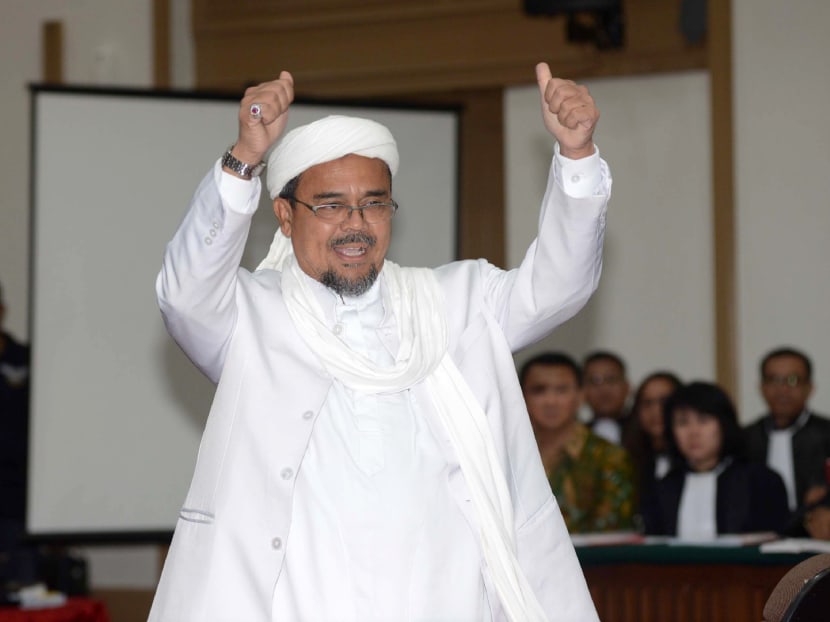 Cleric Rizieq Shihab gestures as he arrives in court to testify in the blasphemy trial of Jakarta's Christian governor Basuki Tjahaja Purnama. Photo: AFP