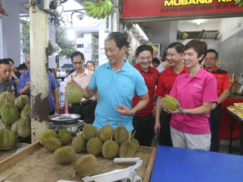 Education Minister Ong Ye Kung (in blue) visiting a durian stall during his ministerial community visit to Jurong Central Division with National Development Minister Lawrence Wong and Manpower Minister Josephine Teo.