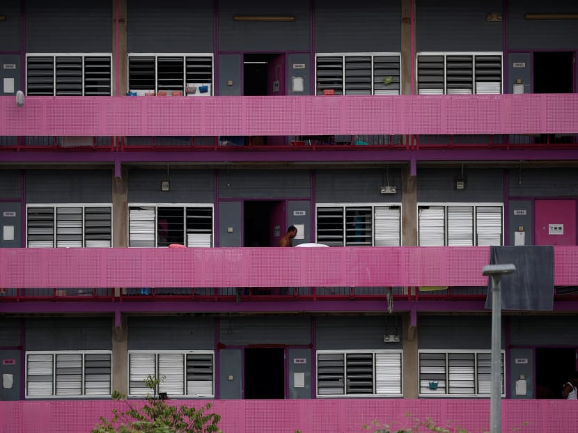 Migrant workers walk outside their rooms in a dormitory amid the Covid-19 outbreak in Singapore.