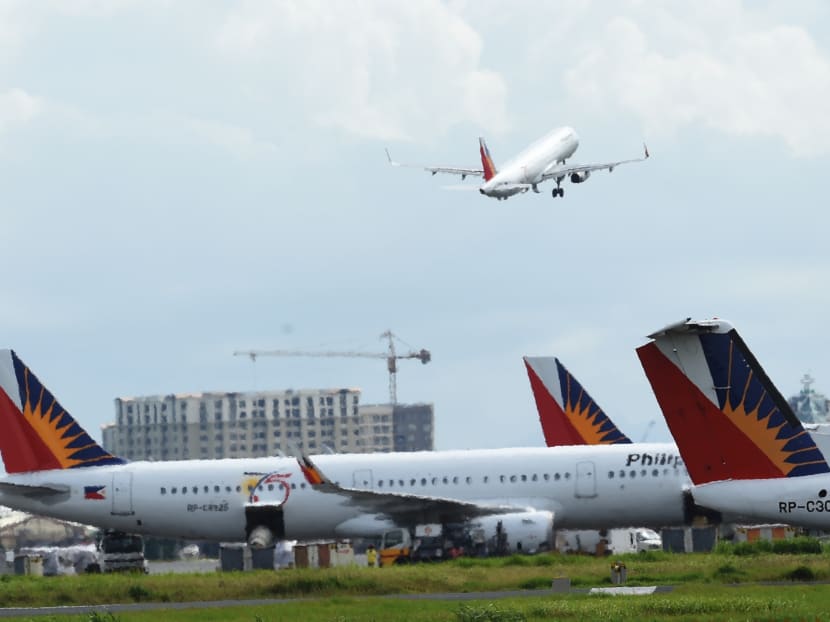 In this photo taken on Sept 13, 2016, Philippine Airlines planes are parked while another takes off at the international airport of Manila. Photo: AFP