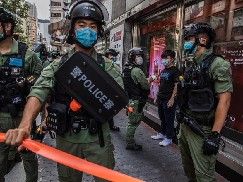 Police question a man as they patrol the area after protesters called for a rally in Hong Kong on Sept 6, 2020 to protest against the government's decision to postpone the legislative council election due to the Covid-19 coronavirus, and the national security law.