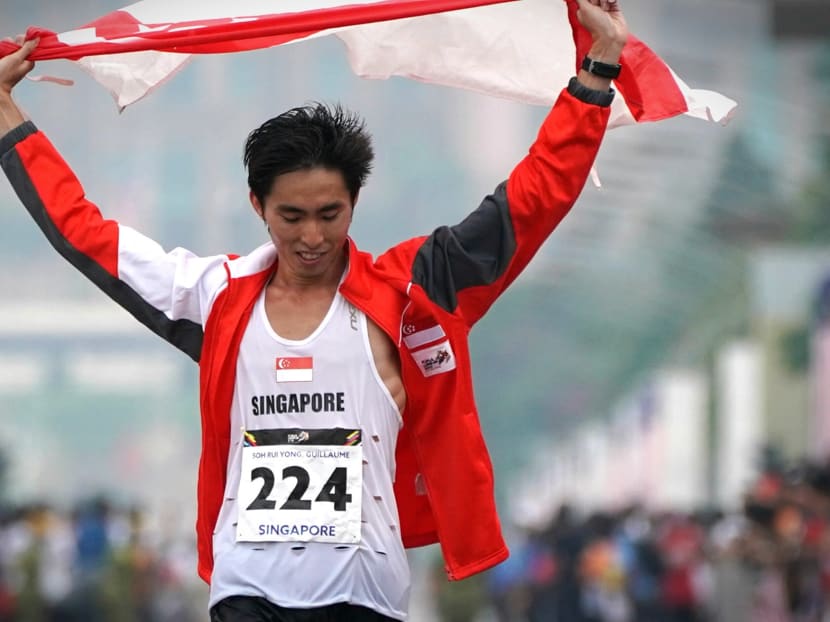 Soh Rui Yong holding the Singapore flag and wearing the singlet that he had cut holes in for ventilation after winning the men's marathon at the 2017 SEA Games in Kuala Lumpur. TODAY file photo