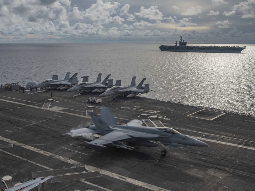 In this photo provided by the US Navy, an F/A-18E Super Hornet lands on the flight deck of the USS Ronald Reagan in the South China Sea, July 6, 2020.