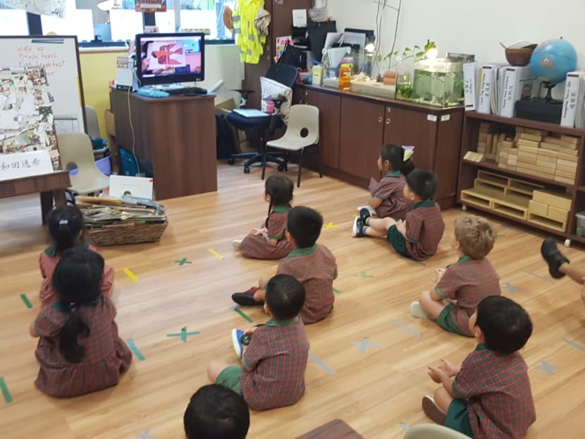 Children in a classroom at an Eton House preschool, seated at a distance from each other.
